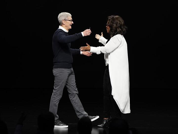Tim Cook, Vorstandsvorsitzender von Apple, und Oprah Winfrey, Moderatorin aus den USA, begrüßen sich bei der Vorstellung neuer Apple-Produkte auf der Bühne. Apple hat einen eigenen Video-Streamingdienst mit dem Namen "Apple TV Plus" vorgestellt.