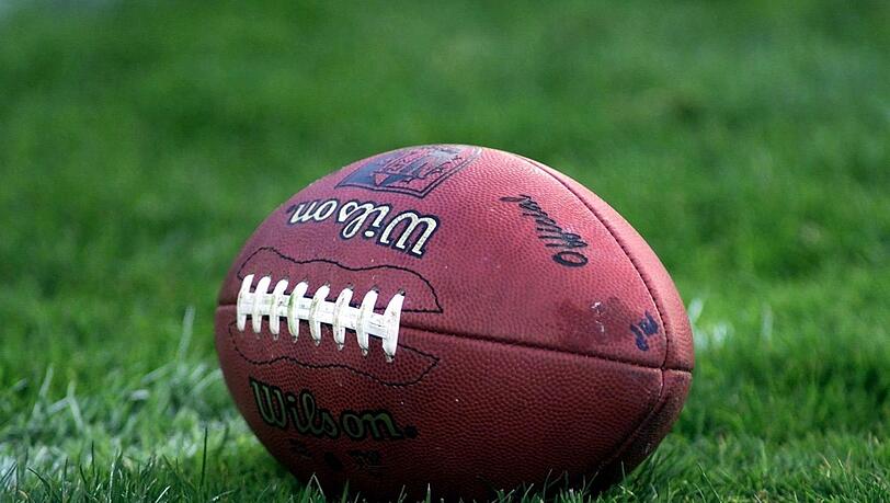 Ein Football liegt auf dem Rasen.