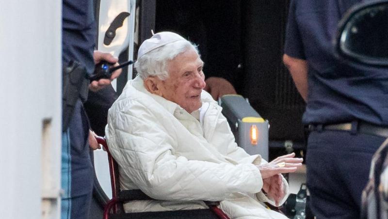 Der emeritierte Papst Benedikt XVI wird mit einem Rollstuhl in einen Bus geschoben. Foto: Daniel Karmann/dpa/Archivbild