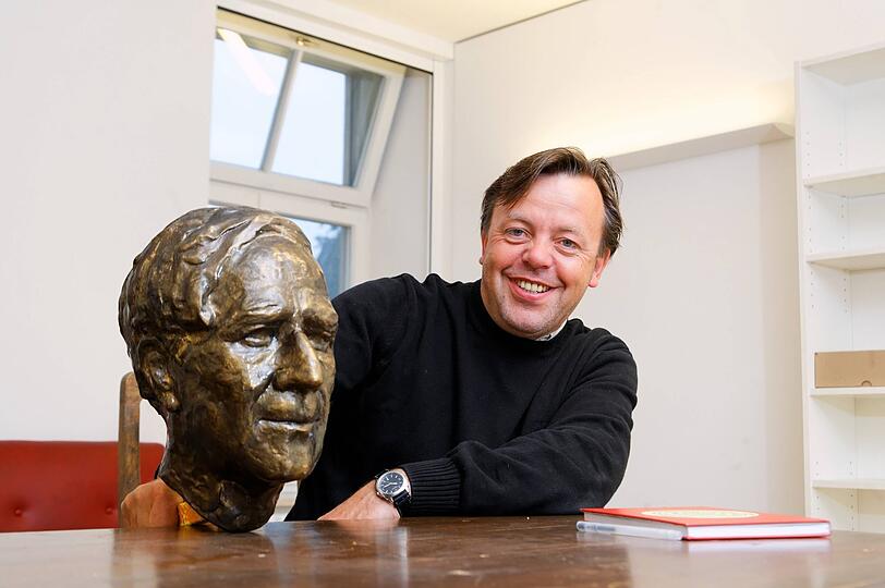 Jochen Noch, bis 2024 Direktor der Falckenberg-Schule, mit einer Büste des Namenspatrons.