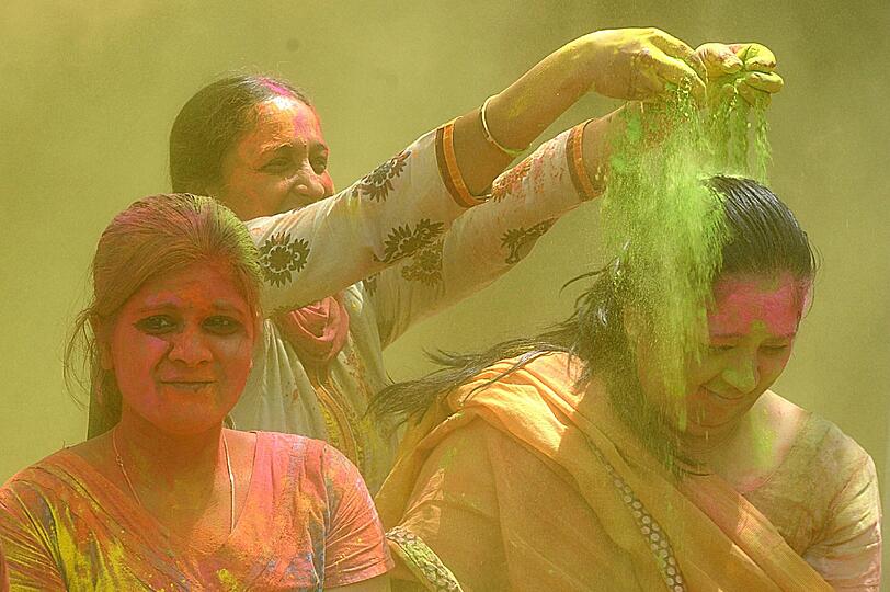 In Hyderabad bewerfen sich indische Frauen mit Farbenpulber