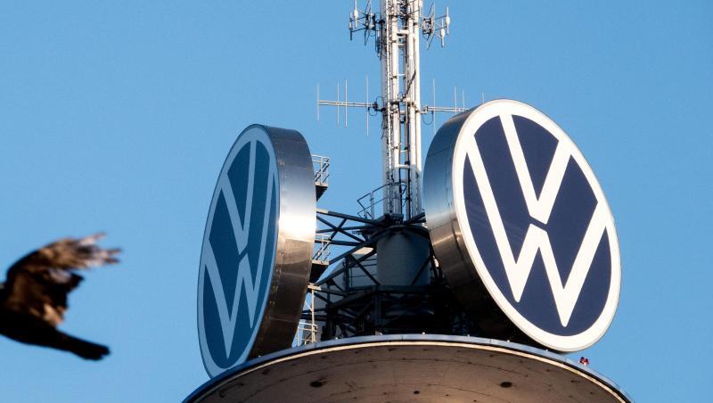 Zwei Vögel fliegen vor dem Logo der Volkswagen AG auf dem VW-Tower. Foto: David Hutzler/dpa/Archivbild