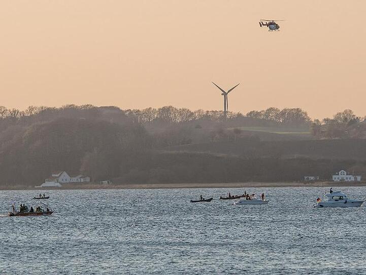 Helfer suchen mit einem Hubschrauber und Booten auf der Förde bei Glücksburg das Wasser ab, nachdem hier ein Ruderboot gekentert war.