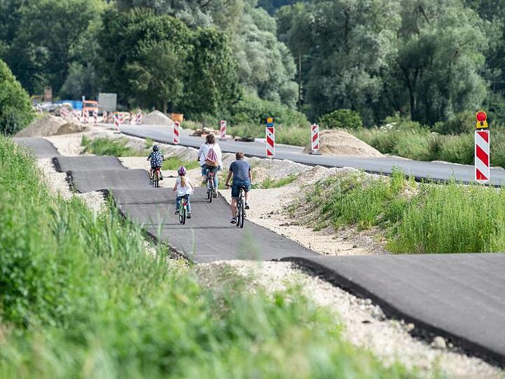 Eine Familie mit zwei Kindern fährt einen als Buckelpiste angelegten Radweg entlang. Foto: Matthias Balk/dpa