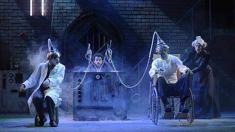 Frankenstein junior (Keith Ramsay, links) will seine Intelligenz auf das Monster (Nic Cain) übertragen, es kommt dann ein wenig anders. Igor (Shaun Chambers) und Frau Blücher (Leanne Pinder) schauen gespannt zu.