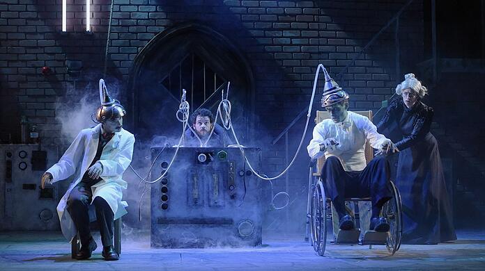 Frankenstein junior (Keith Ramsay, links) will seine Intelligenz auf das Monster (Nic Cain) übertragen, es kommt dann ein wenig anders. Igor (Shaun Chambers) und Frau Blücher (Leanne Pinder) schauen gespannt zu.