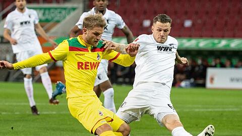 Sebastian Andersson (l) vom 1. FC Köln und Jeffrey Gouweleeuw vom FC Augsburg kämpfen um den Ball.