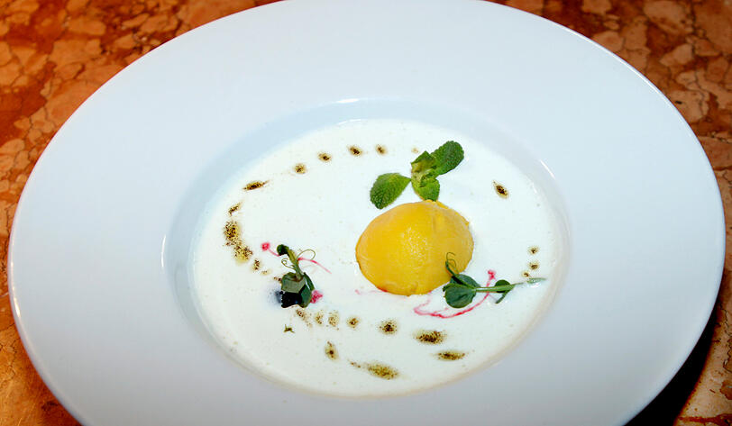Fünfter Gang: Joghurt-Minze-Creme mit Mango-Eis, Vanille-Öl und Frühlingsgrün.