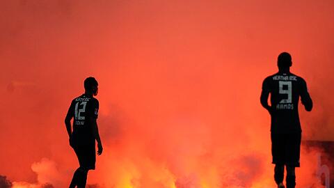 Schon vor dem Platzsturm sorgten die Anhänger in Düsseldorf für Ärger und warfen Pyrotechnik auf den Rasen.