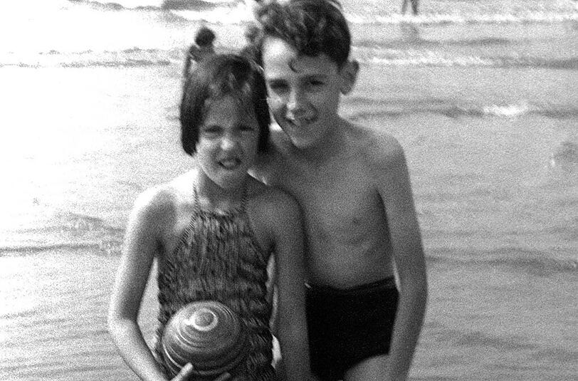 Der erste Urlaub: Zwei Kinder stehen in den 50er Jahren am Strand der Nordsee.