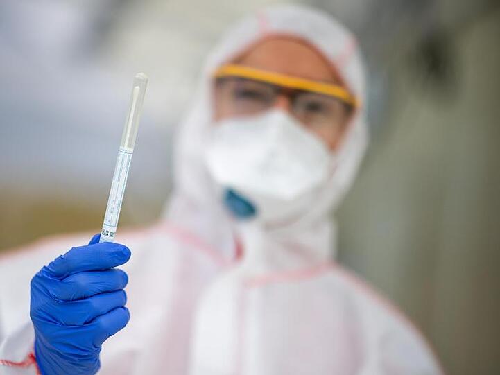 Ein Mitarbeiter hält in einem Abstrichzentrum einen Coronatest-Abstrich in der Hand. Foto: Sebastian Gollnow/dpa/Symbolbild