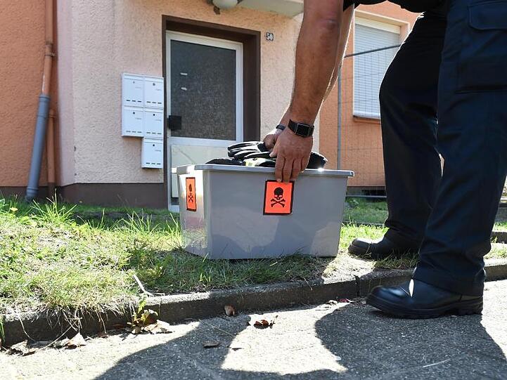 Ein Schlangenexperte stellt eine Kiste vor die Haustür eines Mehrfamilienhauses ab, in dem das giftige Tier vermutet wird.