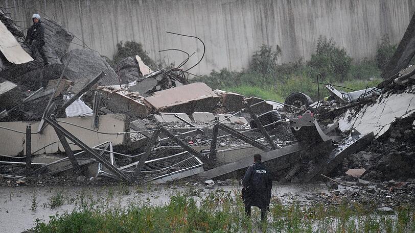 Rettungsarbeiten unter den Trümmern der eingestürzten Morandi Autobahnbrücke.
