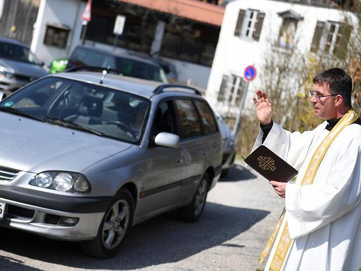 Viele Fahrzeuge stehen Schlange um ihre Osterkörbe bei einer "Drive-In" Speisenweihe von Pfarrer Rudolf Scherer segnen zu lassen. Foto: Angelika Warmuth/dpa