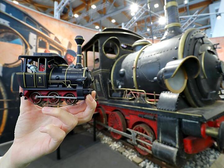 Eine Frau hält die Model-Lokomotive "Emma" aus dem Kinofilm "Jim Knopf und Lukas der Lokomotivführer" in der Hand.