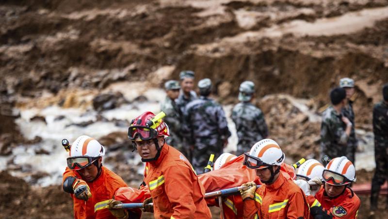 Rettungshelfer tragen eine Leiche. Bei zwei Erdrutschen sind mindestens zwölf Menschen ums Leben gekommen. Rettungshelfer tragen eine Leiche. Bei zwei Erdrutschen sind mindestens zwölf Menschen ums Leben gekommen.