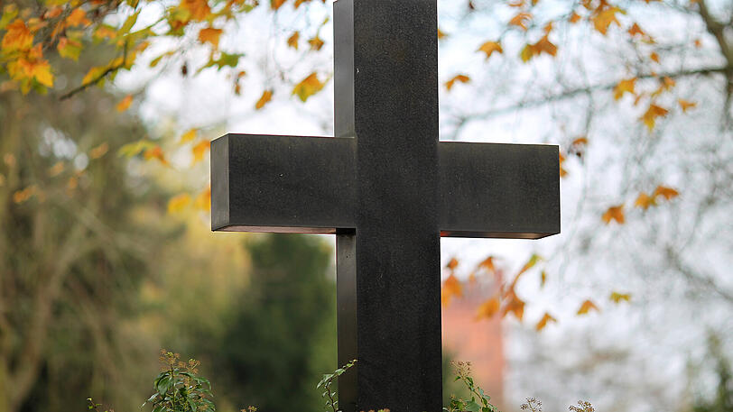 Ein Grabstein in Form eines Kreuzes auf einem Friedhof. (Symbolbild)