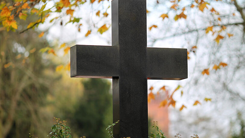 Ein Grabstein in Form eines Kreuzes auf einem Friedhof. (Symbolbild) Ein Grabstein in Form eines Kreuzes auf einem Friedhof. (Symbolbild)