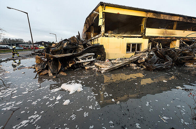Bilder vom Morgen nach dem Brand: Einsatzkräfte der Feuerwehr an den Überresten der Lagerhalle.