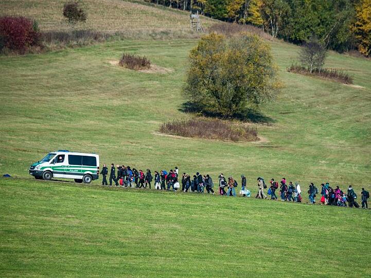 Flüchtlinge laufen hinter einem Fahrzeug der Bundespolizei im Jahr 2015.
