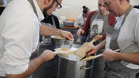 Heiko Seeburg (l.) ist evangelischer Pfarrer und hat sich eine besondere Spendenaktion einfallen lassen: Er hat selbst K&auml;sesp&auml;tzle geschabt. F&uuml;r die Kirchturm-Sanierung in Fessenheim (Landkreis Donau-Ries).