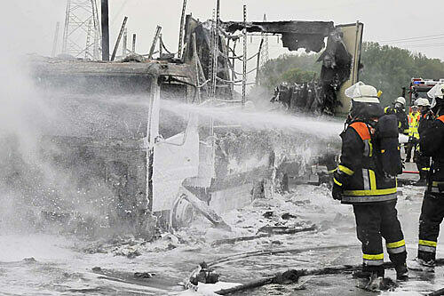 Feuerwehrleute besprühen das Wrack mit Löschschaum.