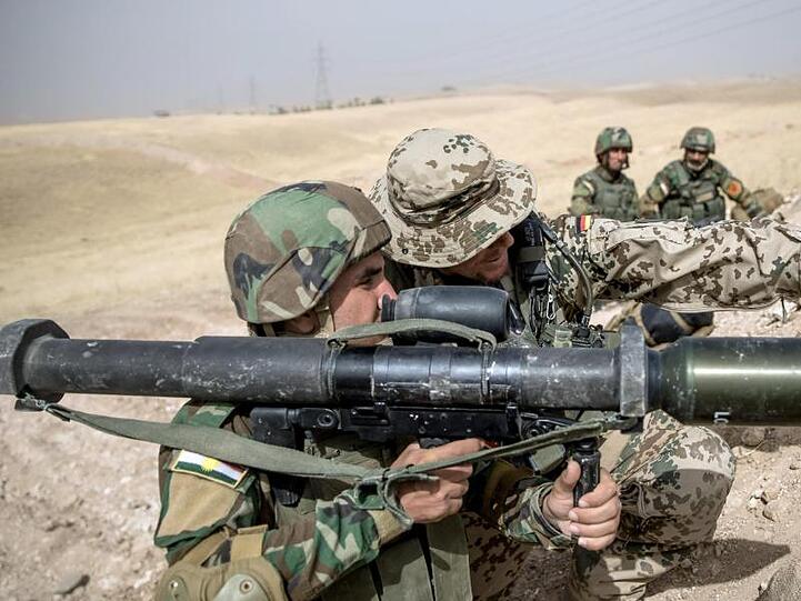 Ein Soldat der Bundeswehr weist einen Angehörigen der Peschmerga im irakischen Bnaslawa bei einer Übung ein.