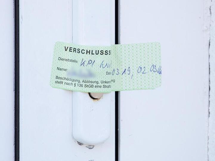 Ein Verschlusssiegel der Würzburger Polizei ist auf die Tür eines Wohnhauses geklebt. Foto: Daniel Karmann/Archivbild