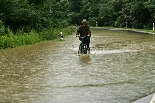 Vom Regen in die Pfütze: Ein Radler bei Grabenstätt.