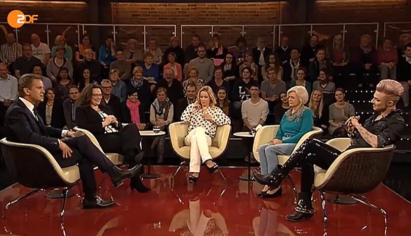 ...ist ein schriller Friseur (rechts) an der Reihe. Alle lachen. Und Frau Heuer sitzt da wie ein Häuflein Elend.