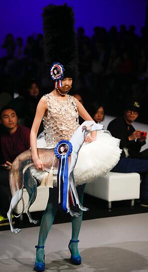 Model mit Bart, Papp-Hund und Rüschenkleidchen... Sowas soll man kommenden Herbst tragen? Designer Andy Ho meint: Ja! - und präsentiert das kreative Chaos bei der Fashion Show in Hongkong.
