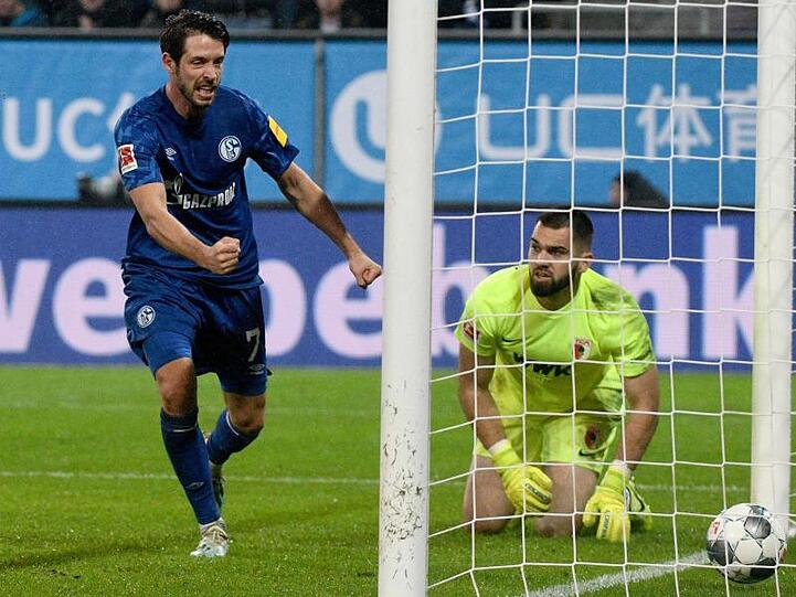 Augsburgs Torwart Tomas Koubek (r.) kniet neben dem jubelnden Schalker Mark Uth. Foto: Stefan Puchner/dpa