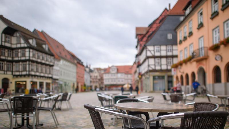 Unbesetzte Tische und Stühle eines geschlossenen Kaffees auf einem Marktplatz.