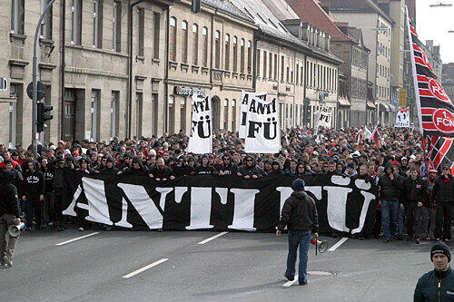 Dieses Bild wie 2004 soll es nicht mehr geben: Damals randalierten Club-Fans in der Fürther Innenstadt. Dennoch laufen die Supporters von der Stadthalle über die Kapellenstraße zum Stadion.