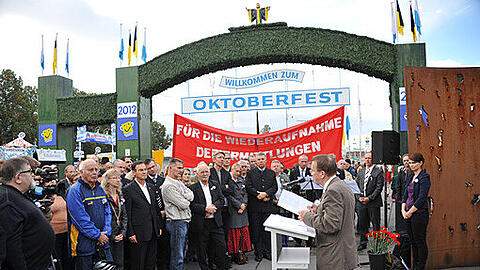 Beim Gedenken an das Oktoberfestattentat wird ein Banner mit der Forderung "Für die Wiederaufnahme des Ermittlungsverfahrens" hochgehalten.