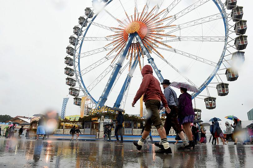 Über die Wiesn schlendern und ein bissl die Leut' anschauen, geht bislang nur mit Regenschirm.