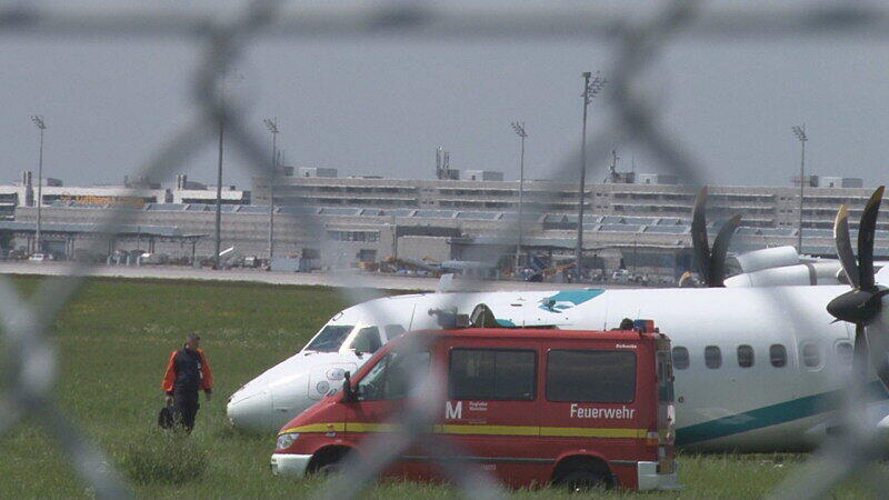 Mitarbeiter des Flughafens in München betrachten die Maschine der italienischen Fluggesellschaft, die am Donnerstag auf dem Münchner Flughafen notlanden musste. Das Flugzeug mit 62 Menschen an Bord hatte kurz nach dem Start in Richtung Venedig umdrehen müssen, weil sich Rauch in der Kabine entwickelt hatte. Bei der Landung wurden fünf Personen leicht verletzt, die Maschine kam neben der Landebahn zum Stehen.