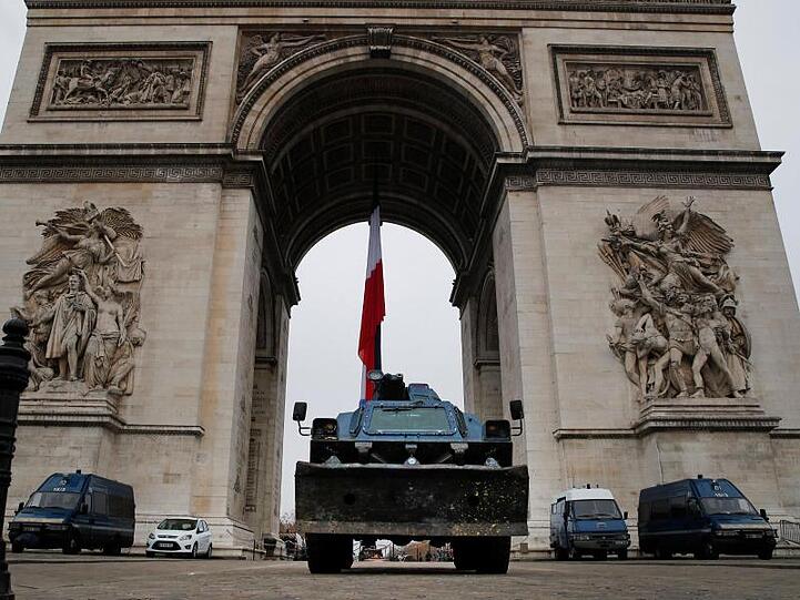 Polizeifahrzeuge parken am Arc de Triomphe in Paris.