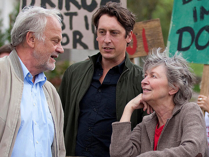 Ober- gegen Unterrieslingen: Elisabeth Rossbauer (Elisabeth Schwarz) und ihr Sohn Peter (Hans Löw, Mitte) demonstrieren mit den Unterrieslingern gegen den Verkauf der Kirche, der von Gottfried Häberle (Christian Pätzold) befürwortet wird