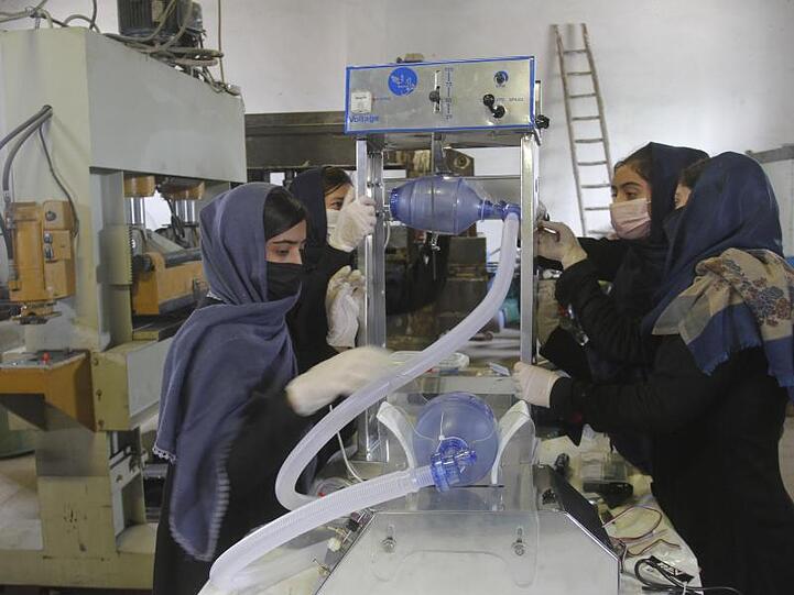Eine Gruppe junger Frauen arbeitet an zwei Arten preiswerter Beatmungsgeräte, die sie unter Verwendung von Toyota-Autoersatzteilen entwickelt haben.