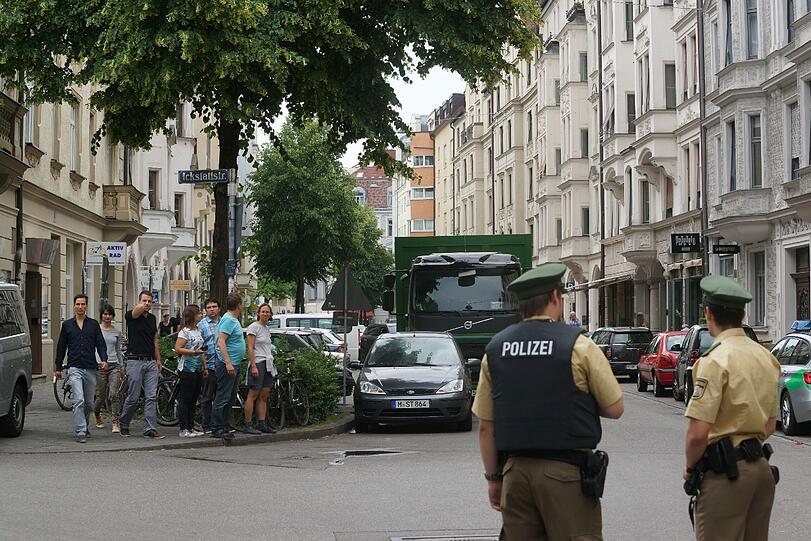 Polizisten sperren den Einsatzort im Glockenbachviertel ab. Manche tragen schusssichere Westen.