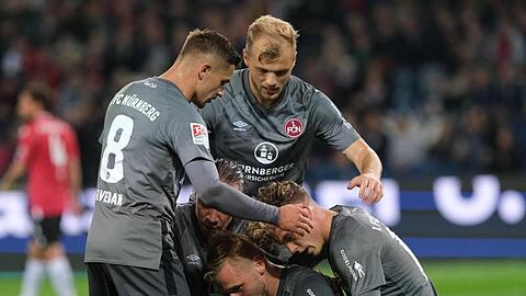 Nürnbergs Spieler feiern Torschütze Hanno Behrens (unten, M) nach seinem Treffer zum 2:0 gegen Hannover 96.