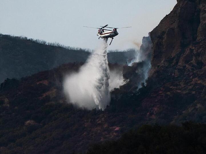 Ein Chinook Hubschrauber bei einem Löscheinsatz bei Thousand Oaks. Die Feuer haben bereits Hunderte Quadratkilometer Wald und Tausende Häuser zerstört - und noch immer ist ein Ende des Schreckens nicht abzusehen.