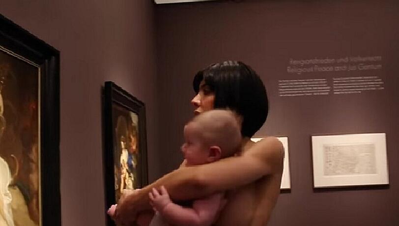 Milo Moire wie immer nackt, mit Baby auf dem Arm in Münster Milo Moire wie immer nackt, mit Baby auf dem Arm in Münster