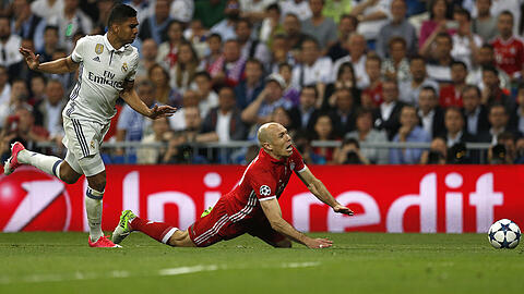 Bayern-Star Arjen Robben (rechts) fällt nach einem Foul durch Real Madrids Casemiro. Den Elfmeter verwandelt Robert Lewandowski.
