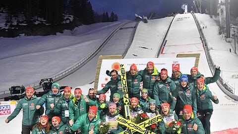 Das deutsche Skisprungteam feiert mit dem Mixed-Team deren Sieg.
