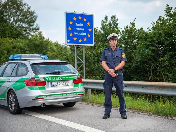 Ein Beamter der bayerischen Grenzpolizei steht an einem Grenzübergang. Foto: Lino Mirgeler/Archivbild