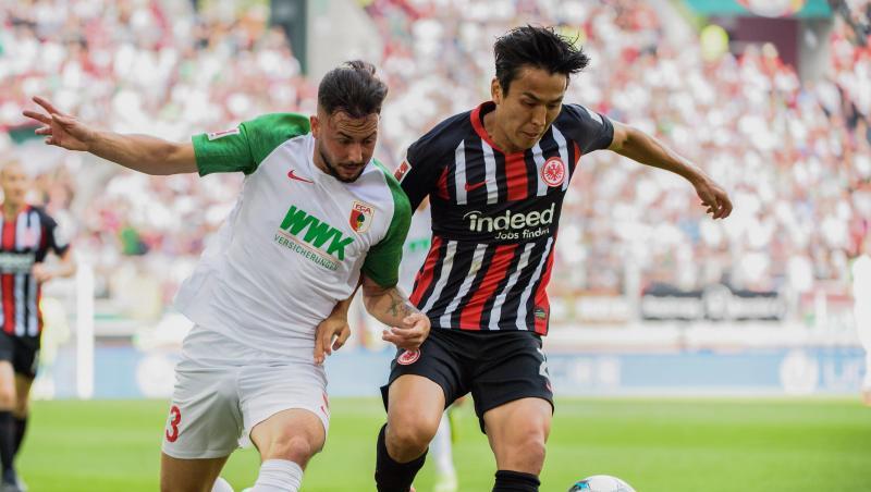 Marco Richter von Augsburg und Makoto Hasebe von Frankfurt (l-r.) im Zweikampf um den Ball. Foto: Matthias Balk Marco Richter von Augsburg und Makoto Hasebe von Frankfurt (l-r.) im Zweikampf um den Ball. Foto: Matthias Balk