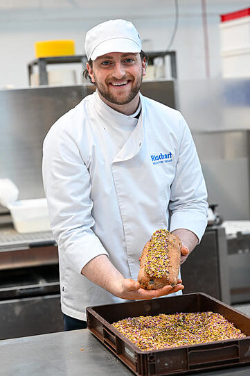 Gleich ist der vegane Stollen fertig. Christoph Lentschig tunkt ihn in bunte getrocknete Blüten. Die sehen nicht nur hübsch aus, sondern geben ein besonderes Aroma.