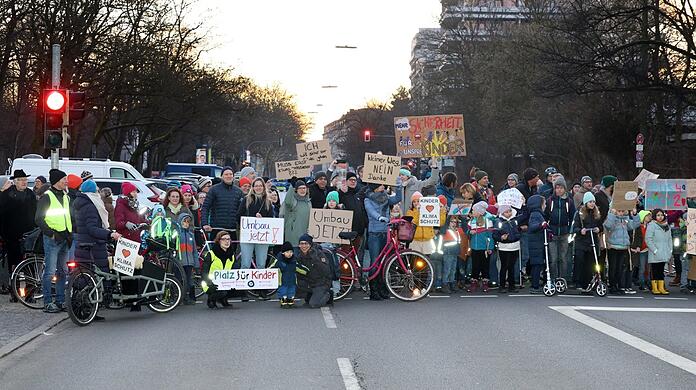 Rund 200 Eltern und Kinder demonstrierten vergangene Woche vor Schulbeginn für einen Umbau der Karl-Theodor-Straße. Die Pläne dafür liegen schon seit Jahren vor, im Februar diskutiert der Stadtrat erneut darüber.